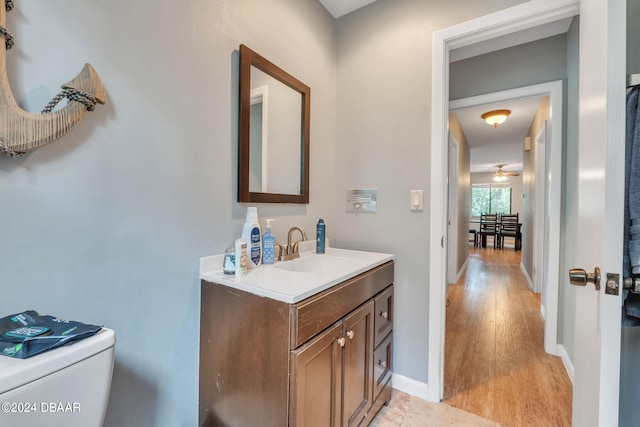 bathroom featuring wood-type flooring, toilet, and vanity