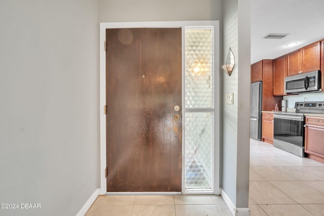 interior space with stainless steel appliances and light tile patterned floors