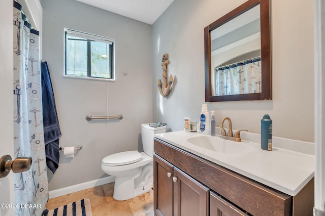 bathroom with toilet, vanity, and tile patterned floors