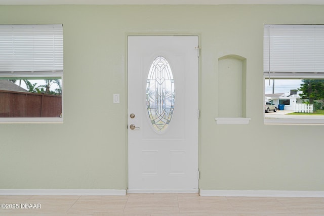 foyer entrance featuring baseboards and a healthy amount of sunlight