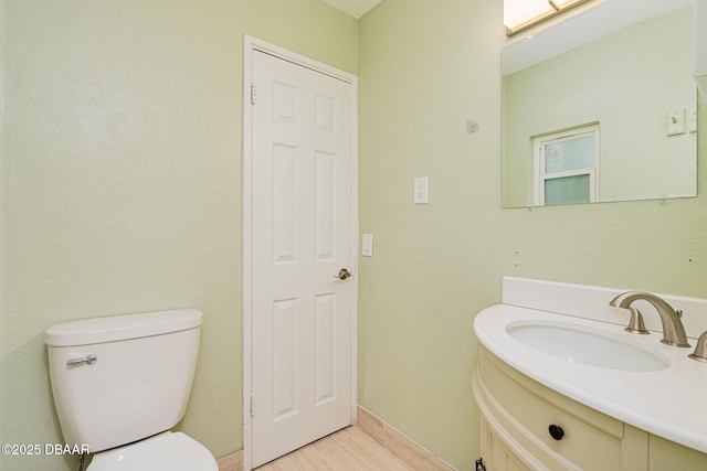 bathroom with vanity, toilet, and wood finished floors