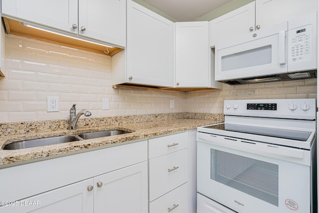 kitchen with white appliances, white cabinets, a sink, and decorative backsplash