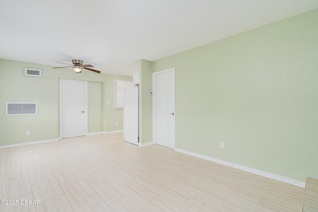 unfurnished room featuring a ceiling fan, visible vents, and baseboards