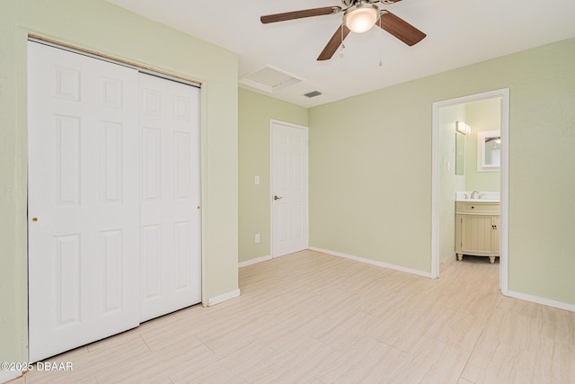 unfurnished bedroom featuring a sink, visible vents, baseboards, a closet, and attic access