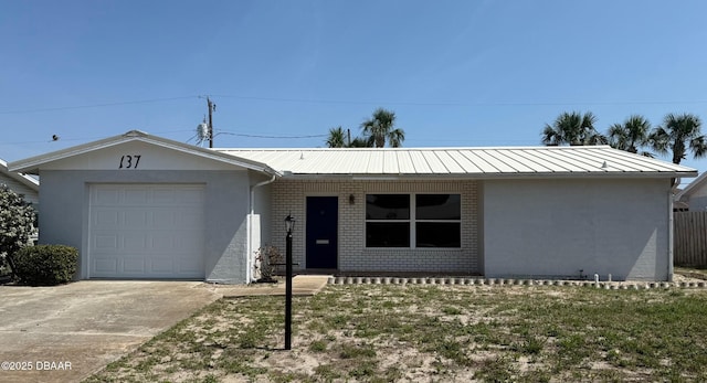 137 Beau Rivage Dr, Ormond Beach, FL 32176 - ranch-style home featuring a garage, concrete driveway, metal roof, brick siding, and a standing seam roof