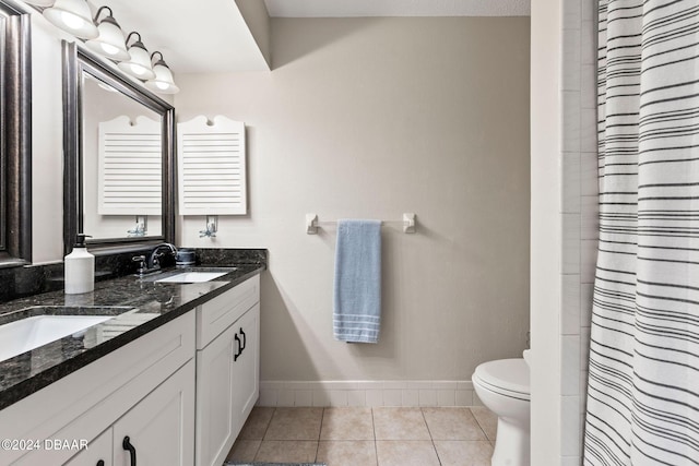 bathroom featuring tile patterned floors, vanity, toilet, and walk in shower