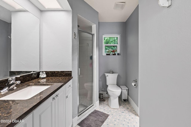 bathroom with toilet, a shower with shower door, and vanity