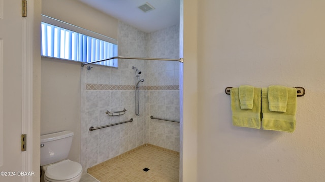 bathroom featuring tiled shower and toilet