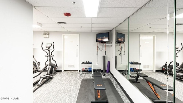 workout area featuring carpet floors and a drop ceiling