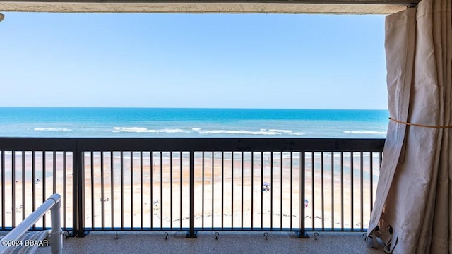 balcony featuring a water view and a view of the beach