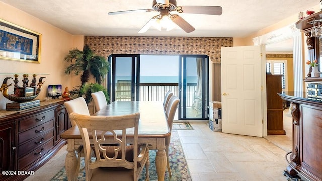 dining room featuring a water view and ceiling fan