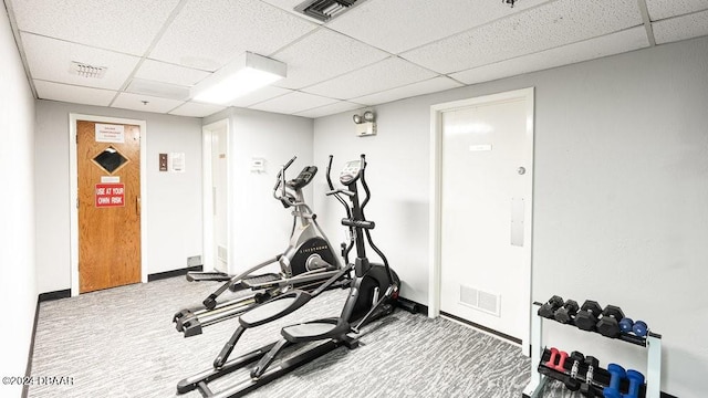 exercise room featuring carpet flooring and a drop ceiling