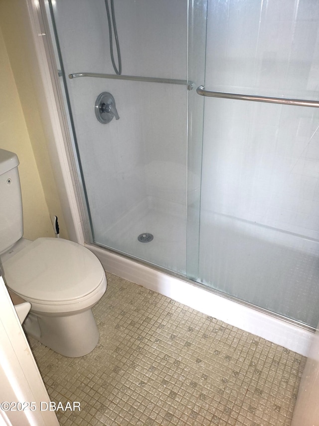 bathroom with toilet and a shower with door