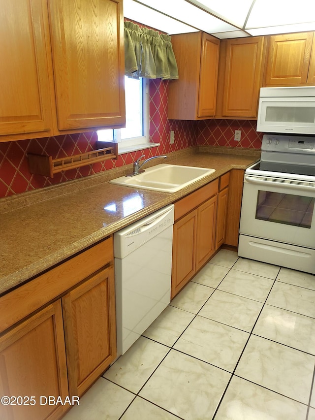 kitchen with decorative backsplash, sink, light tile patterned floors, and white appliances