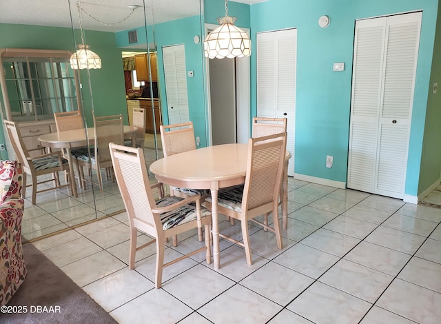 tiled dining space with a textured ceiling