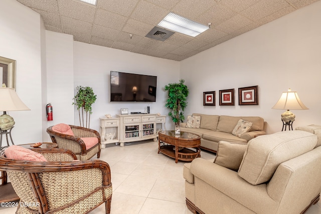 living room featuring a paneled ceiling and light tile patterned flooring