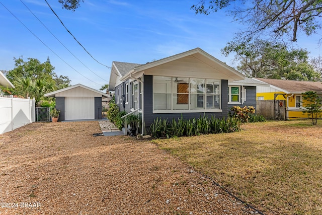 view of front of home featuring an outbuilding, a garage, and a front yard