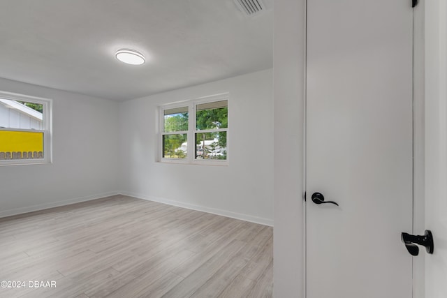 unfurnished room with light wood-type flooring and a wealth of natural light