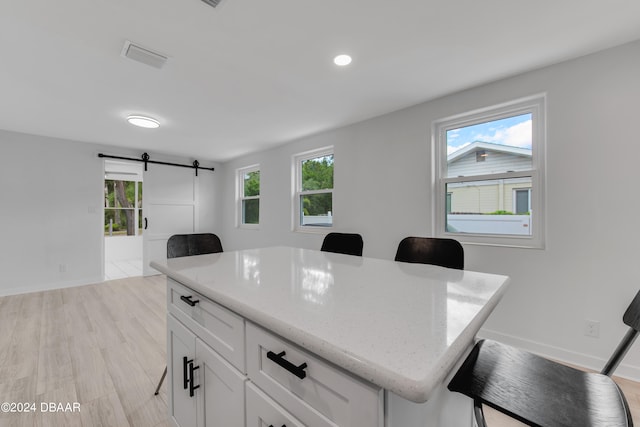 office area with a barn door and light hardwood / wood-style flooring