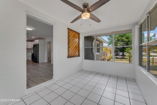 unfurnished sunroom featuring ceiling fan