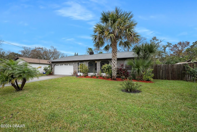 view of front facade featuring a front yard, concrete driveway, fence, and an attached garage