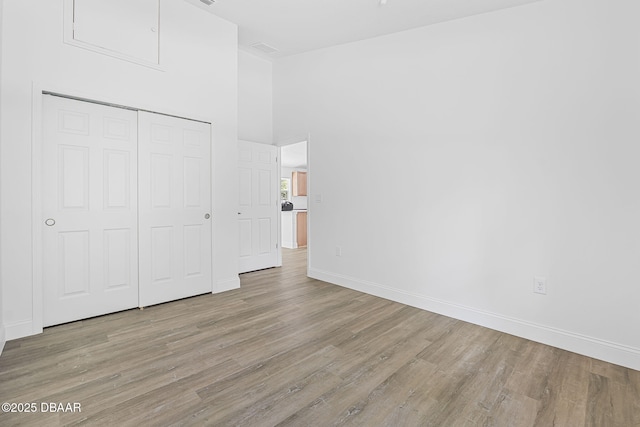5620 Ridgewood Ave, Deleon Springs, FL 32130 - unfurnished bedroom featuring baseboards, wood finished floors, high vaulted ceiling, and a closet
