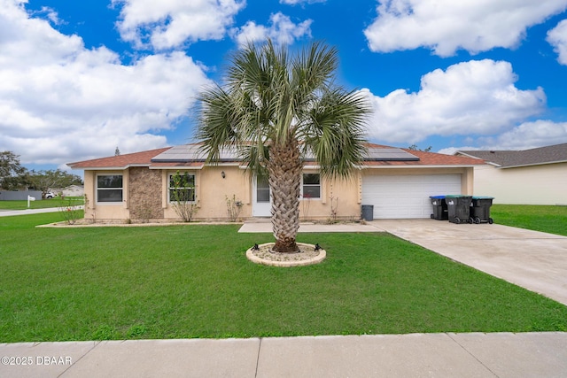 ranch-style home with a front yard, roof mounted solar panels, an attached garage, and concrete driveway