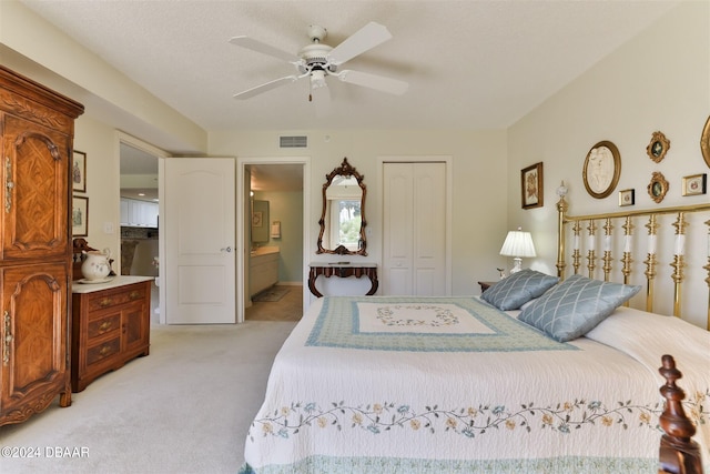 bedroom featuring a closet, visible vents, ensuite bathroom, light carpet, and ceiling fan