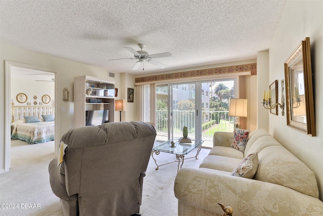 carpeted living area featuring ceiling fan, visible vents, and a textured ceiling