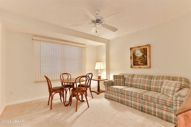 carpeted living room with a ceiling fan and baseboards