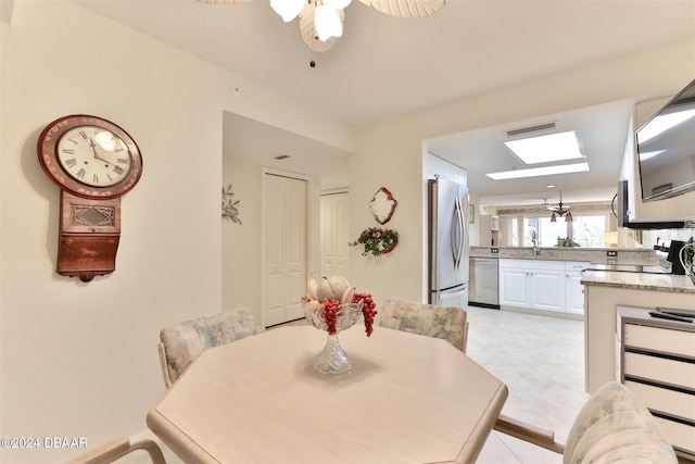 dining area with a skylight, visible vents, and a ceiling fan