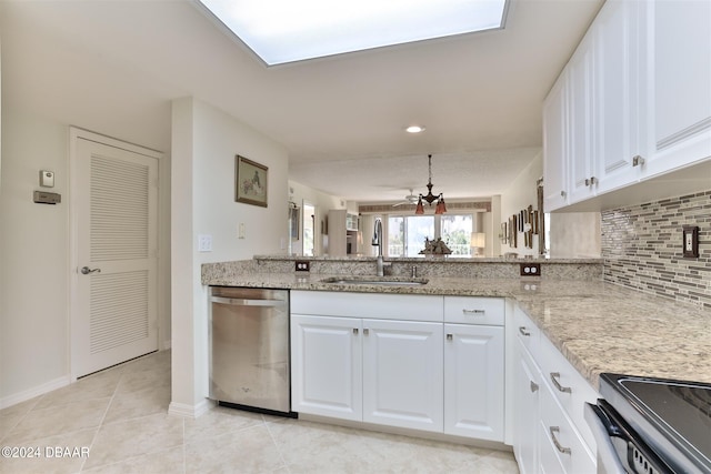 kitchen with appliances with stainless steel finishes, a sink, light stone counters, and decorative backsplash