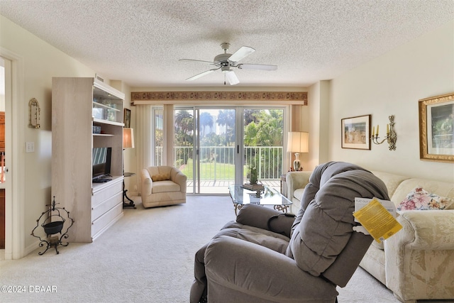 carpeted living area featuring ceiling fan and a textured ceiling