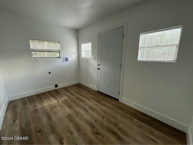 spare room with a wealth of natural light and dark hardwood / wood-style flooring