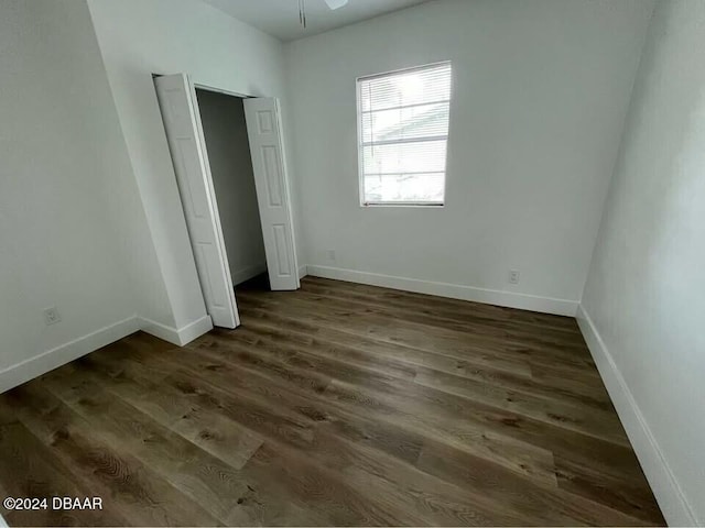 unfurnished bedroom with dark wood-type flooring