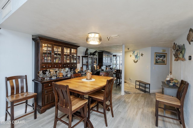 dining room with light wood-type flooring and baseboards