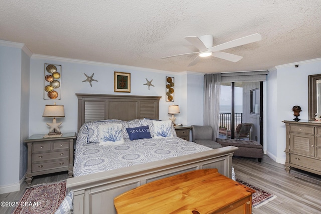 bedroom with access to exterior, wood finished floors, a textured ceiling, ornamental molding, and baseboards