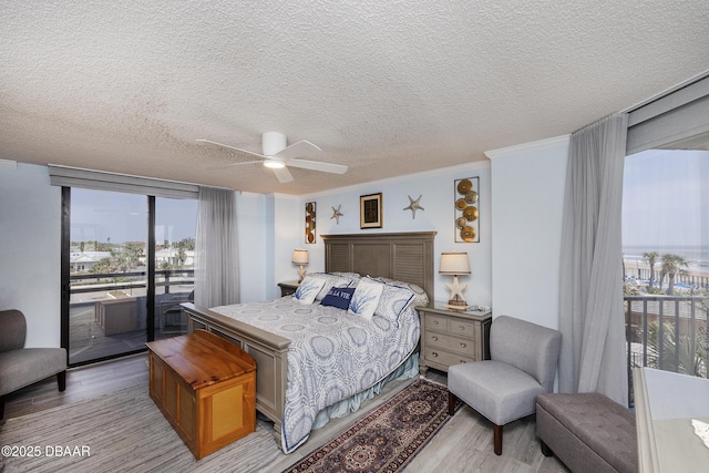 bedroom with access to outside, light wood-type flooring, a textured ceiling, a ceiling fan, and crown molding