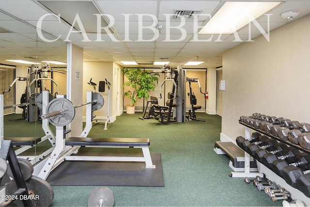 workout area featuring a drop ceiling and baseboards