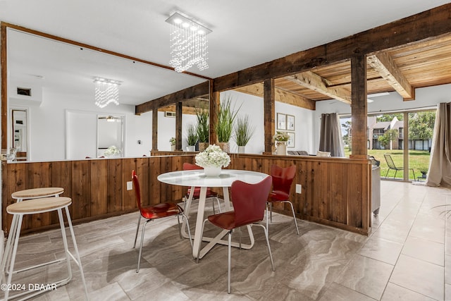 dining room with a notable chandelier and wooden walls