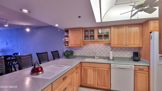 kitchen with white appliances, ceiling fan, sink, and tasteful backsplash