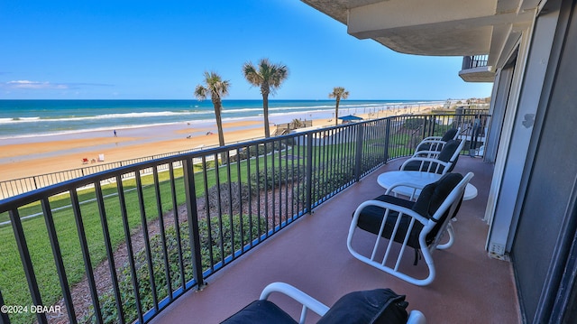 balcony featuring a view of the beach and a water view