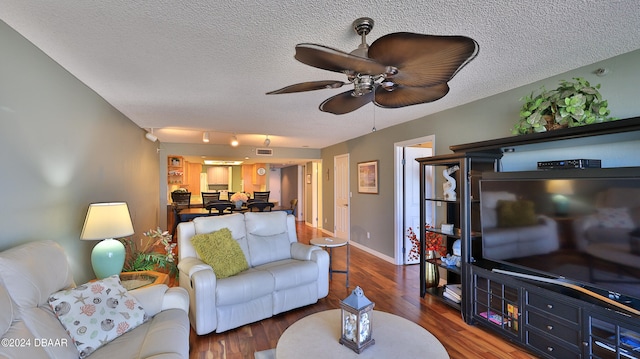 living room featuring a textured ceiling, hardwood / wood-style floors, and ceiling fan