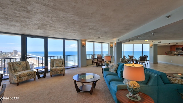 carpeted living room with a water view and floor to ceiling windows