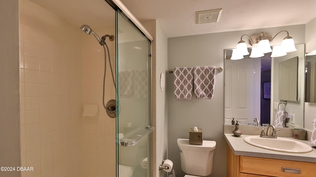 bathroom with an enclosed shower, vanity, and toilet