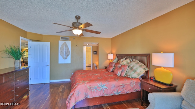 bedroom with ceiling fan, a textured ceiling, and dark hardwood / wood-style flooring