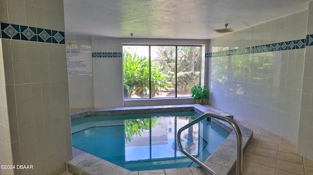 view of swimming pool with an indoor hot tub