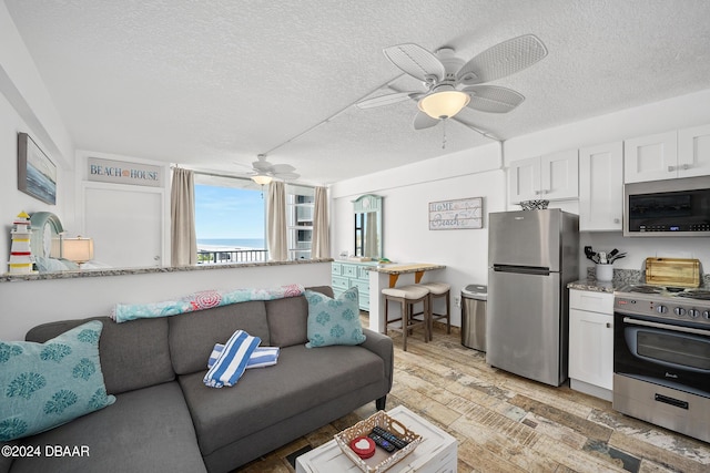 800 N Atlantic Ave Unit 523, Daytona Beach, FL 32118 - living room featuring a textured ceiling, ceiling fan, and light wood-style floors