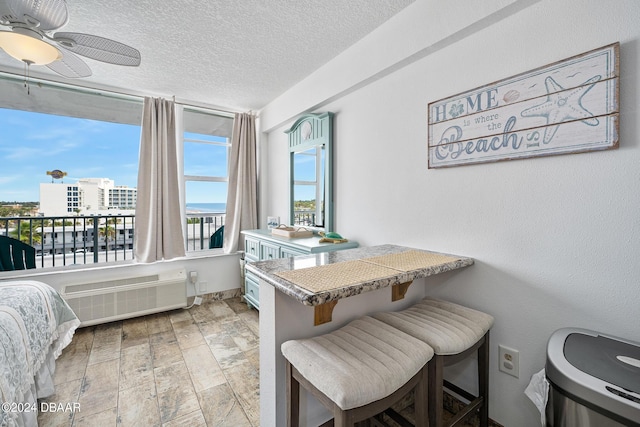 800 N Atlantic Ave Unit 523, Daytona Beach, FL 32118 - dining room featuring a ceiling fan, an AC wall unit, and a textured ceiling