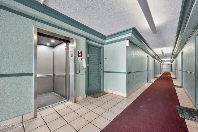 800 N Atlantic Ave Unit 523, Daytona Beach, FL 32118 - corridor with a textured wall, elevator, light tile patterned floors, and a textured ceiling